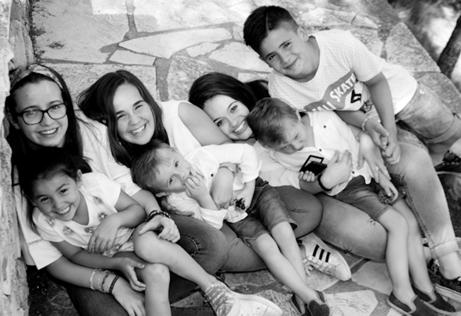 Un grupo de primos tumbados juntos en el suelo, en blanco y negro