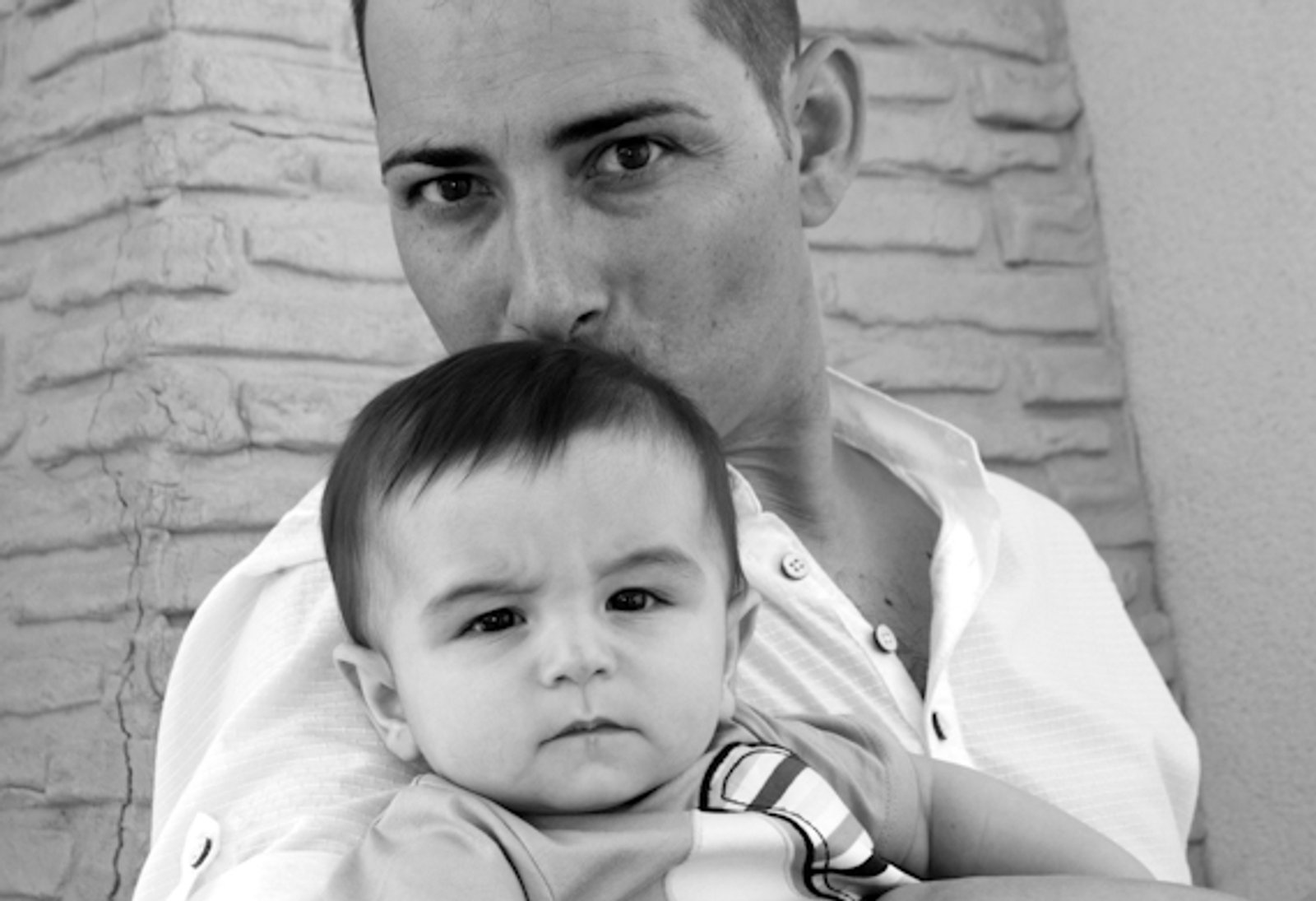 Un padre con su bebé en brazos, en blanco y negro