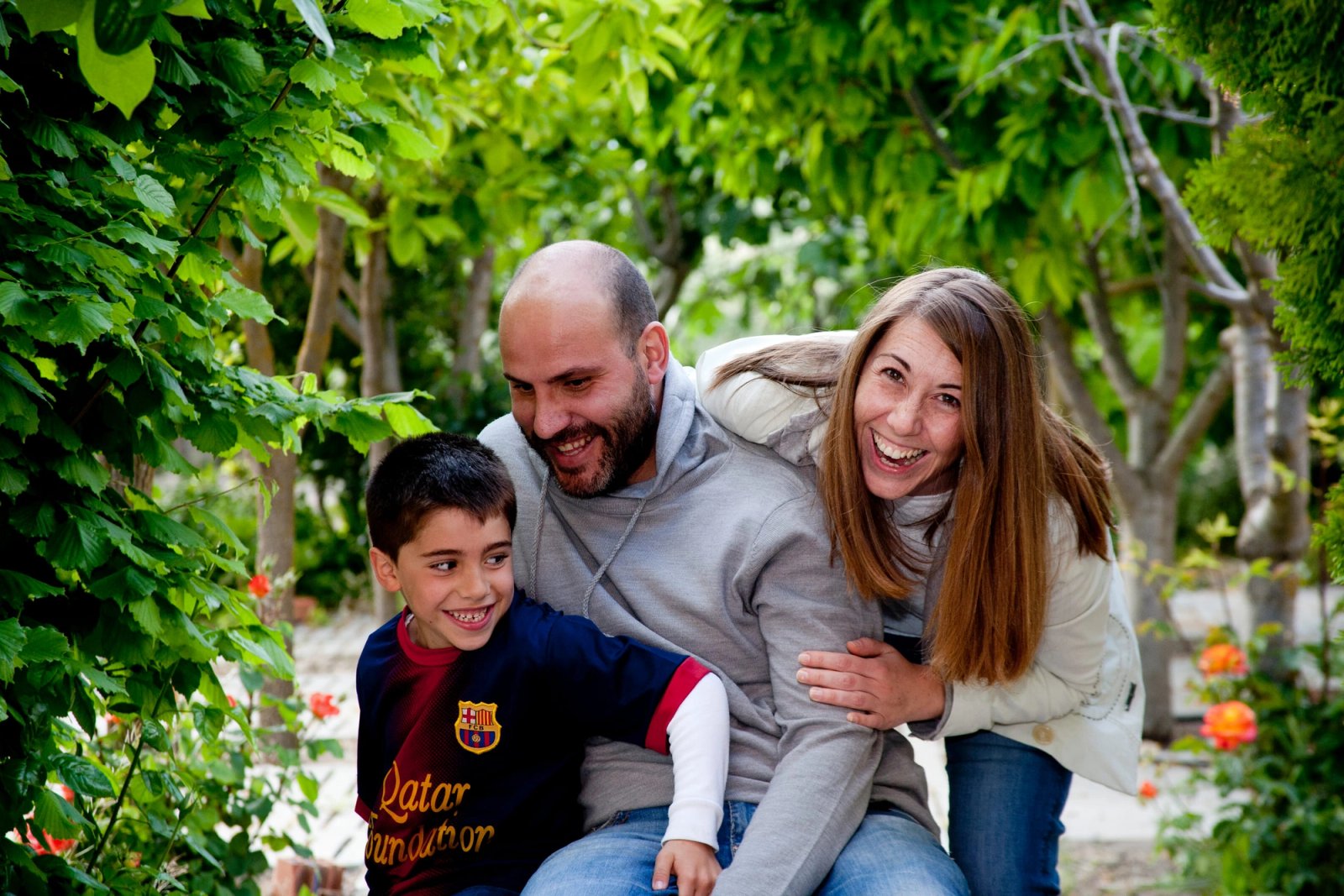 Una familia abrazada en un jardín, riéndose