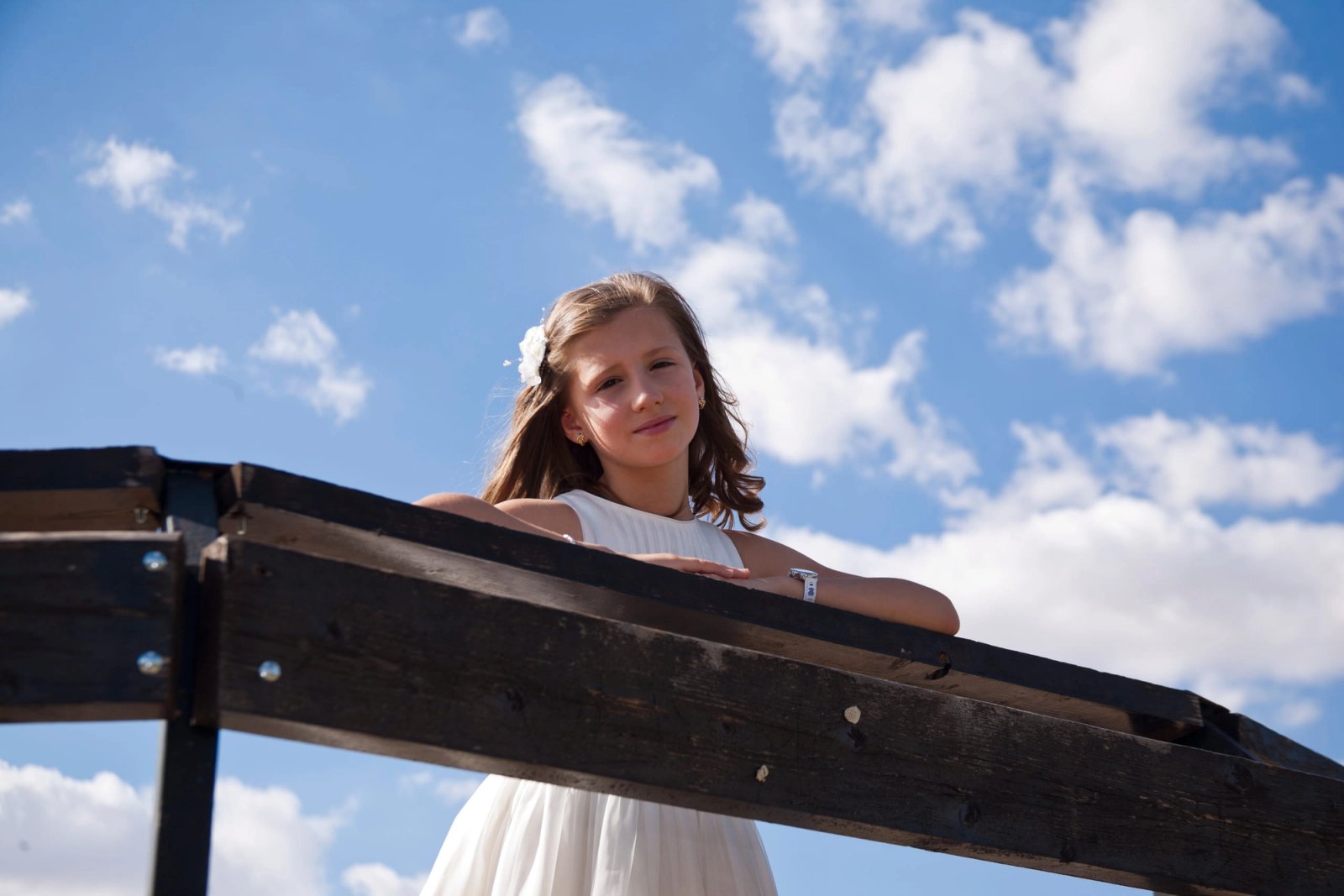Una niña de comunión contra el cielo azul