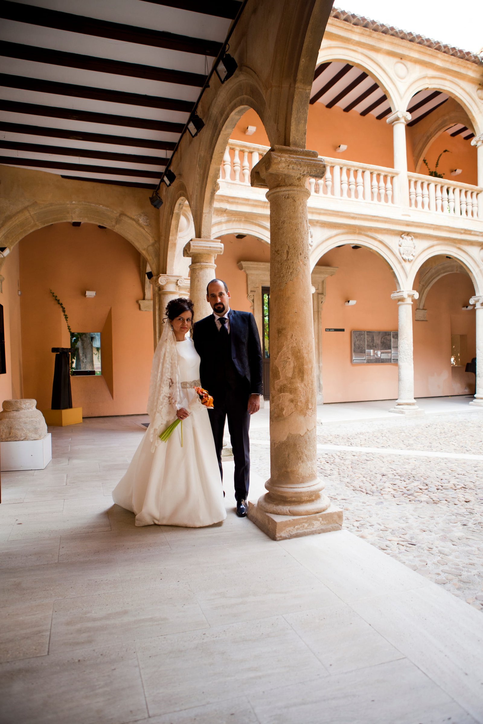 Los novios caminan por el claustro de un palacio