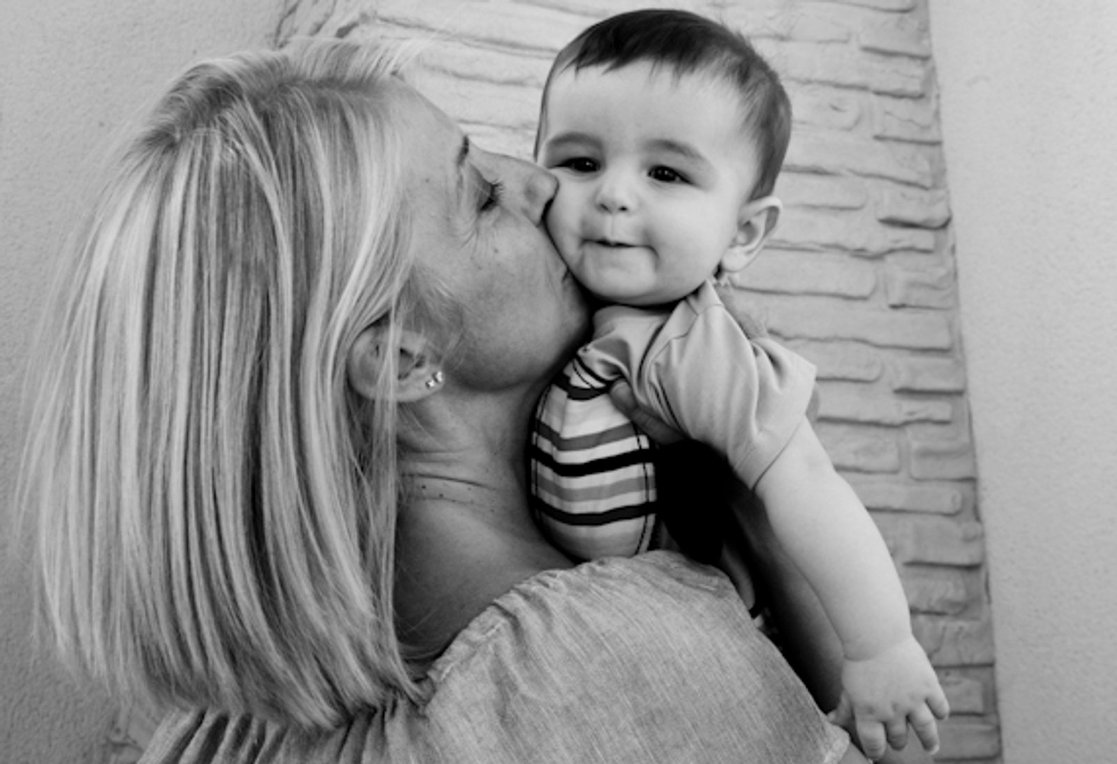Una madre besa a su bebé, en blanco y negro
