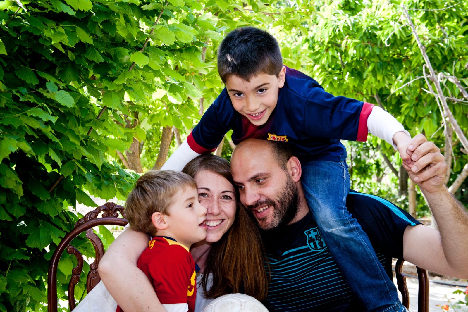 Una familia con dos niños, uno a hombros, entre parras