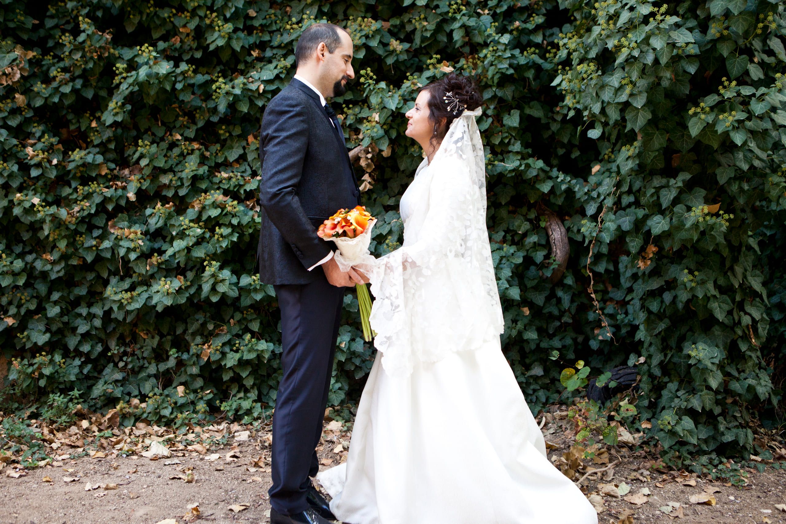 Los novios se miran en un camino entre vegetación