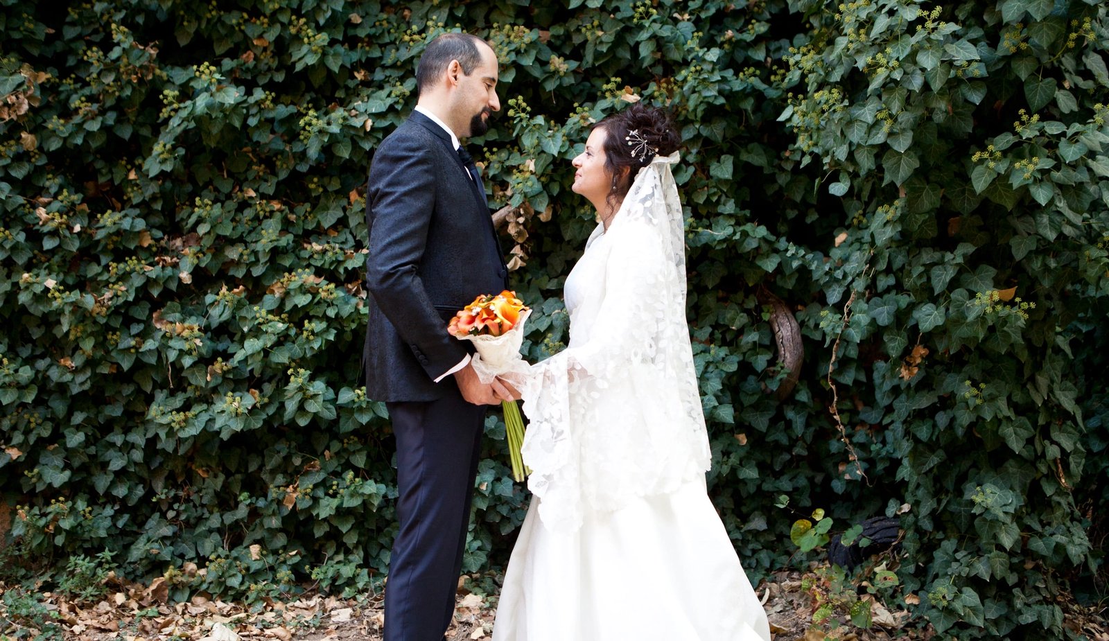 Los novios se miran en un camino entre vegetación