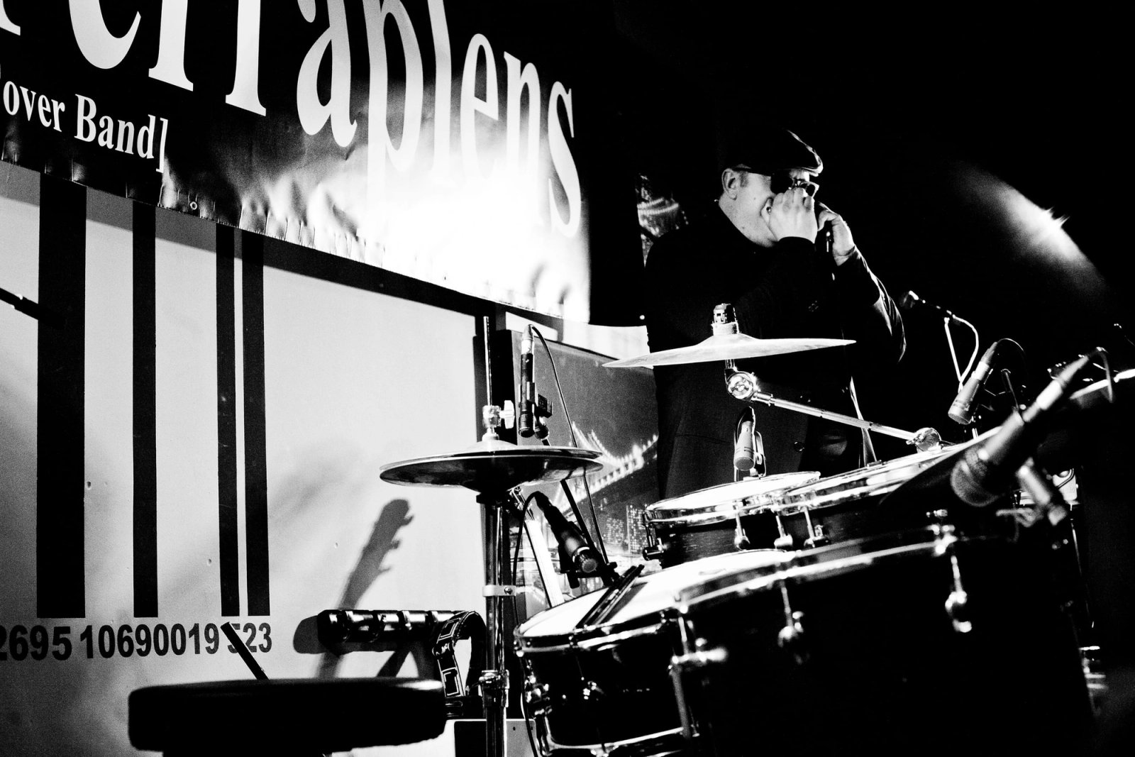 La batería y el escenario durante un concierto, en blanco y negro