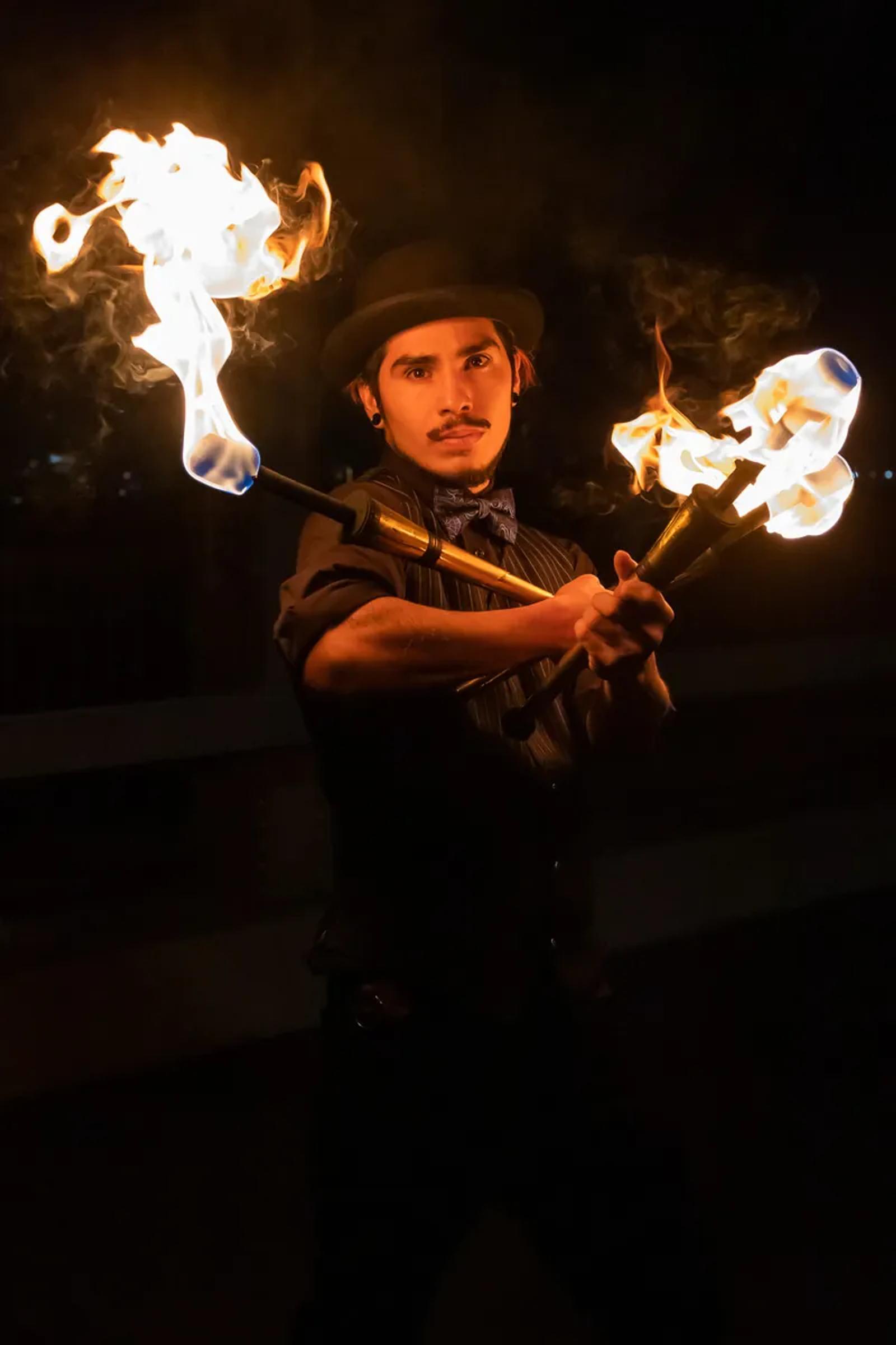 Fire performer spinning poi at night
