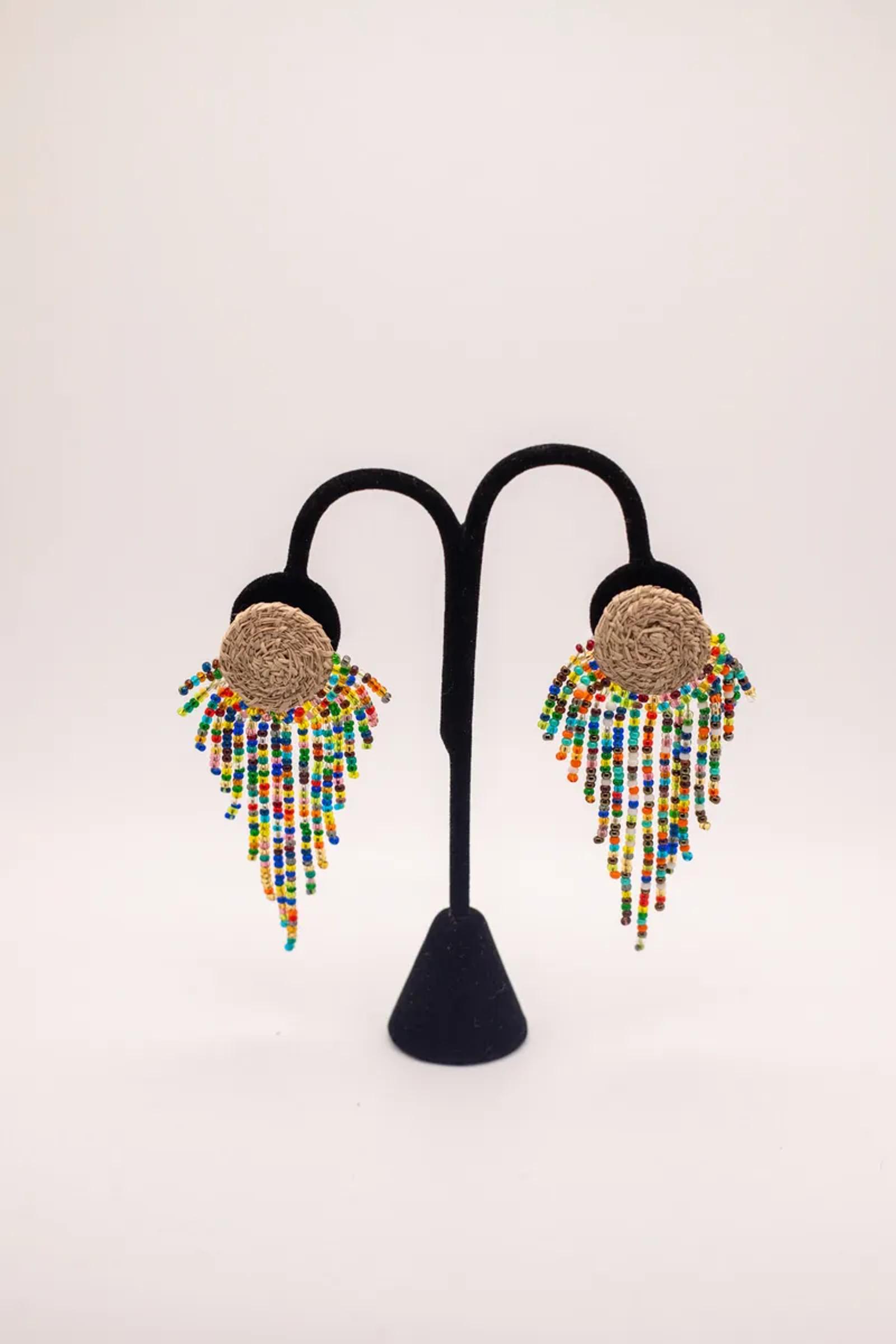 Beaded fringe earrings on a stand