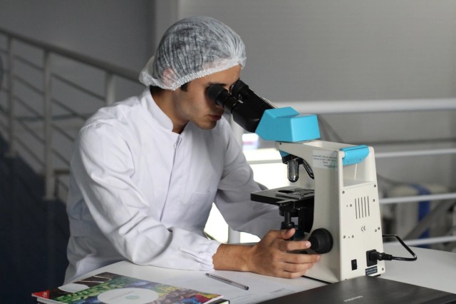 Health care researcher working with a microscope
