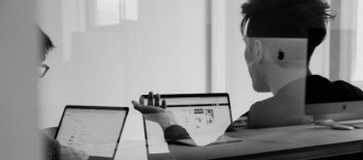 IT colleagues collaborating with laptops