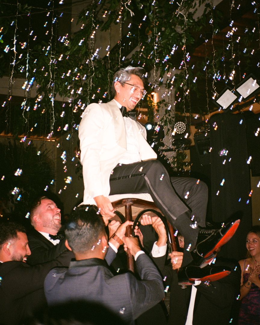 Groom risen on chair during wedding dancing