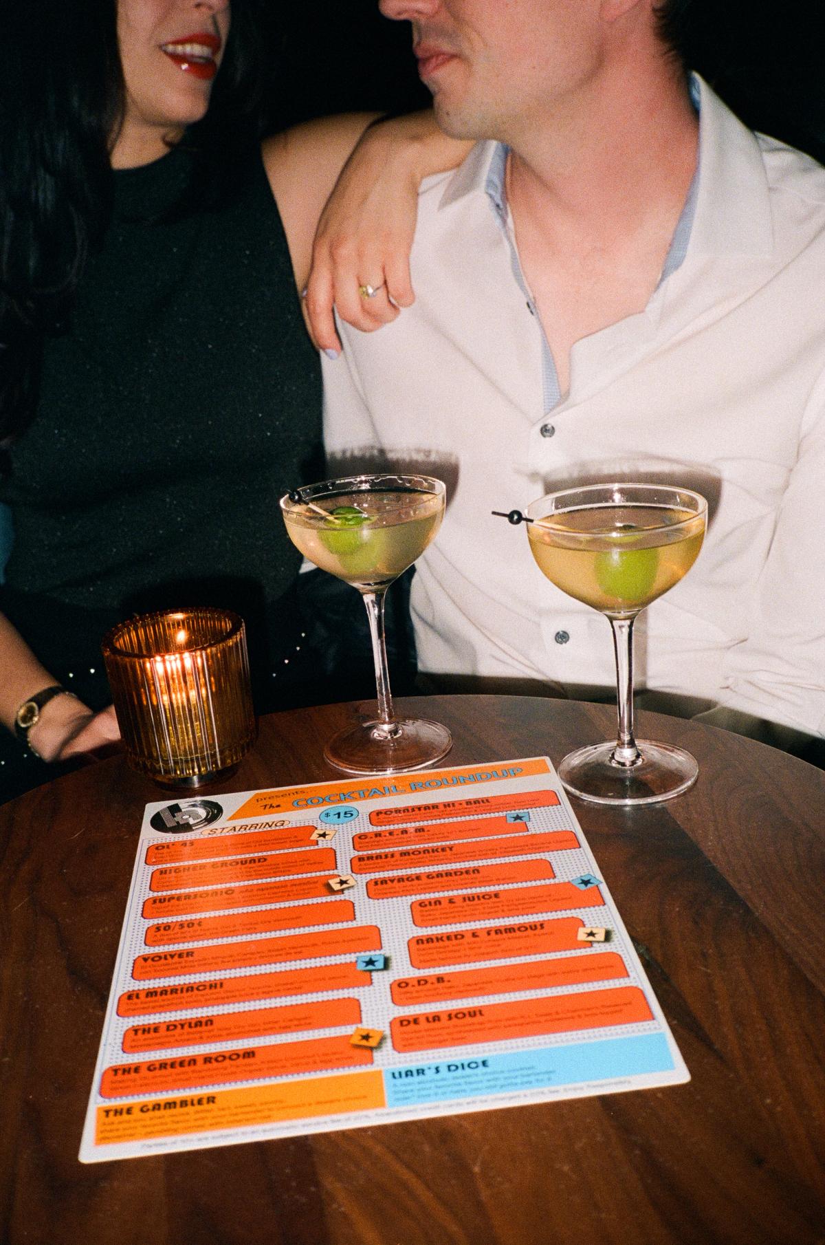 Engaged couple sharing martinis by candlelight at a bar during San Francisco engagement session, lifestyle couple photography
