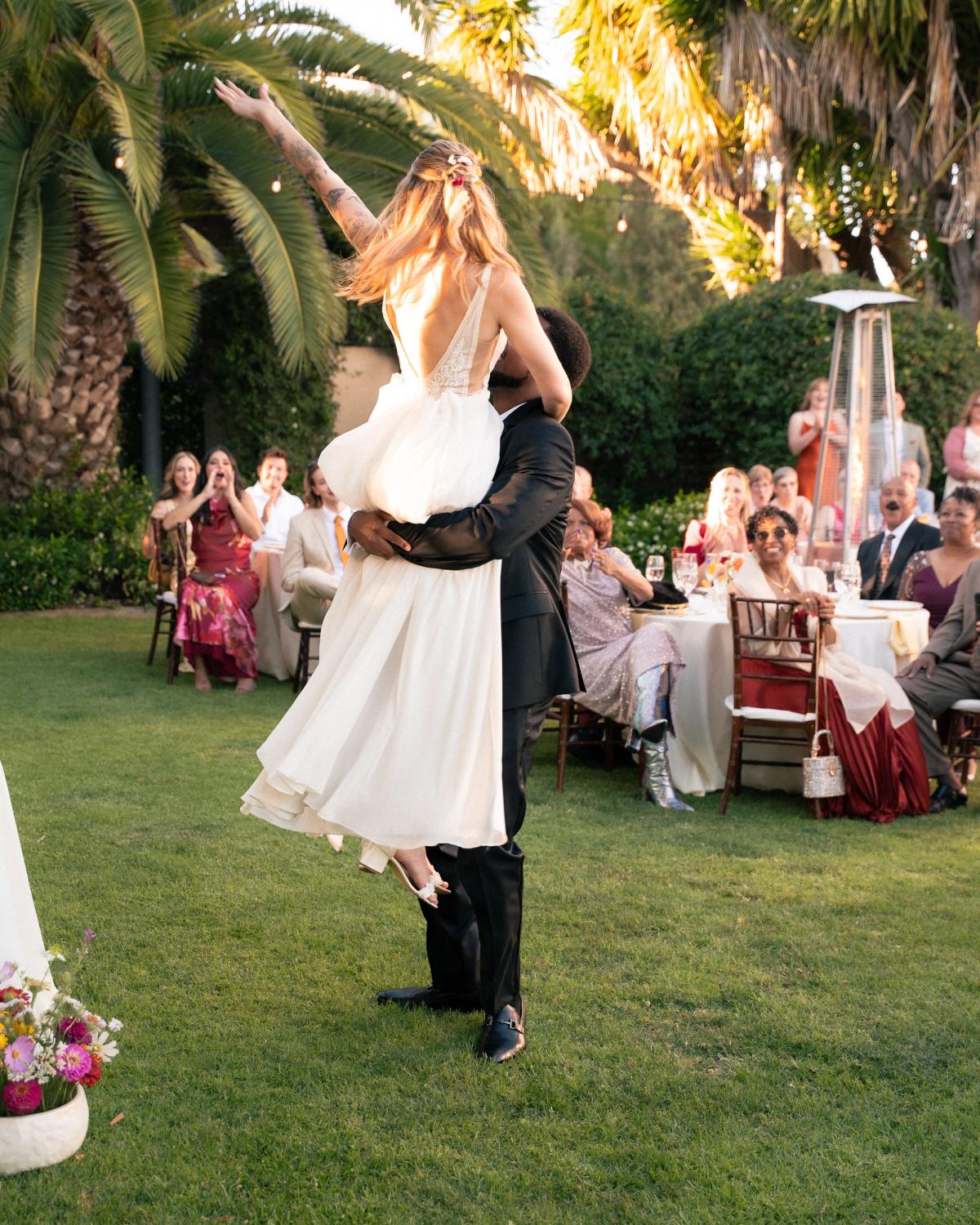 Groom lifting up his bride at their wedding during the first dance