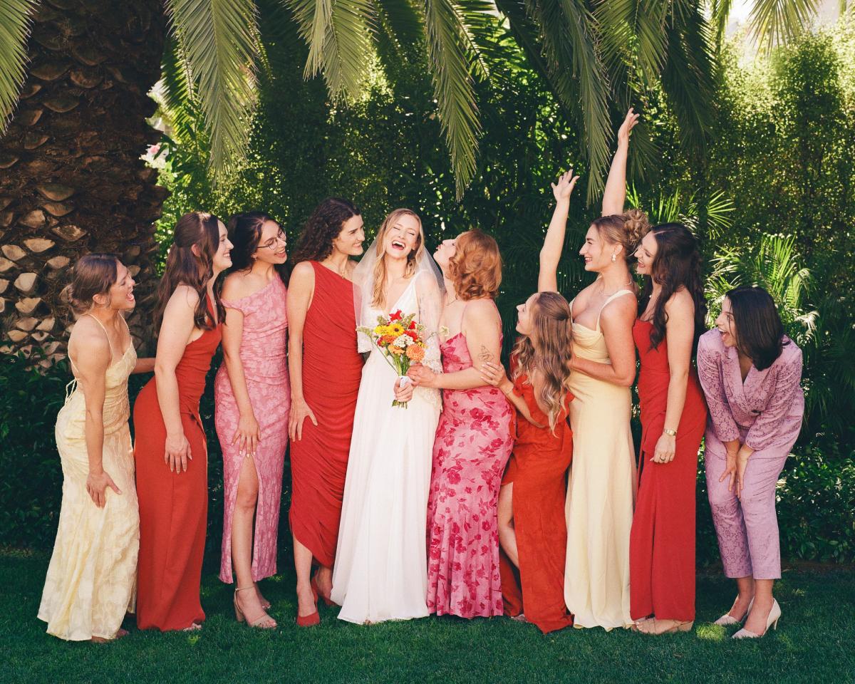 Bridesmaids celebrating with a bride underneath a palm tree