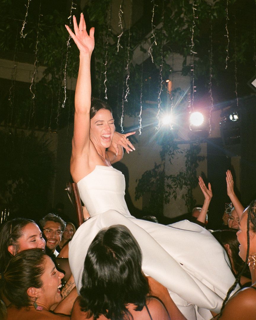 Bride being risen on a chair dancing at a wedding