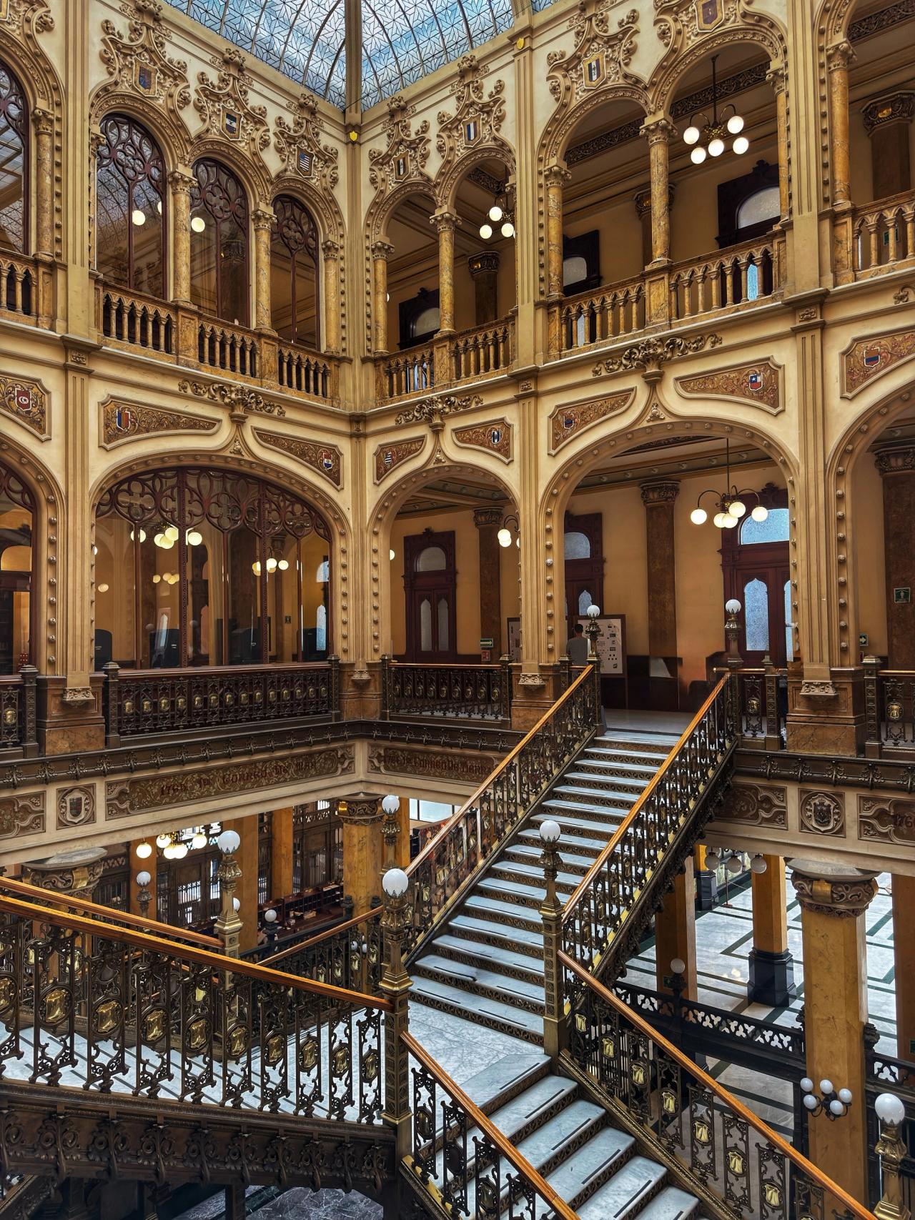 Escaleras, arcos ornamentados y techo acristalado del Palacio Postal.
