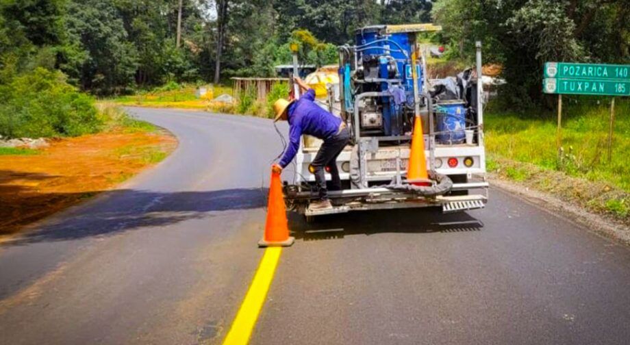 Cuadrilla y vehículo de señalamiento pintan las líneas de la carretera Pachuca–Tuxpan.