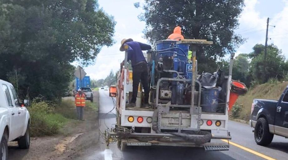 Cuadrilla y vehículo de señalamiento pintan las líneas de la carretera Pachuca–Tuxpan.