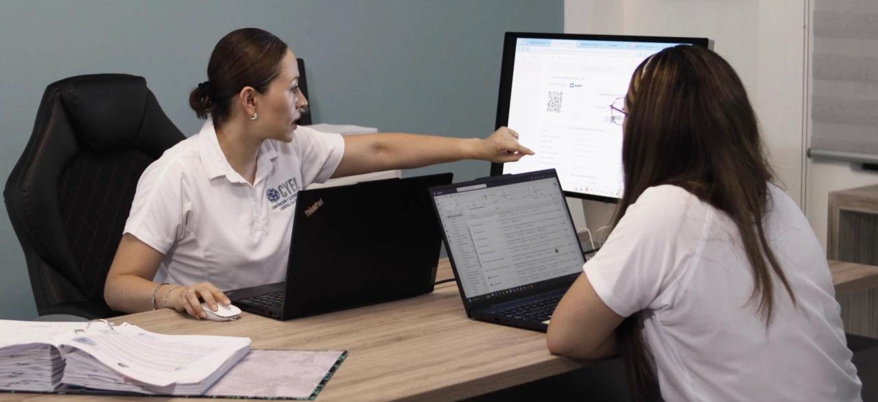 Dos colaboradoras de CYEL revisando información en pantalla