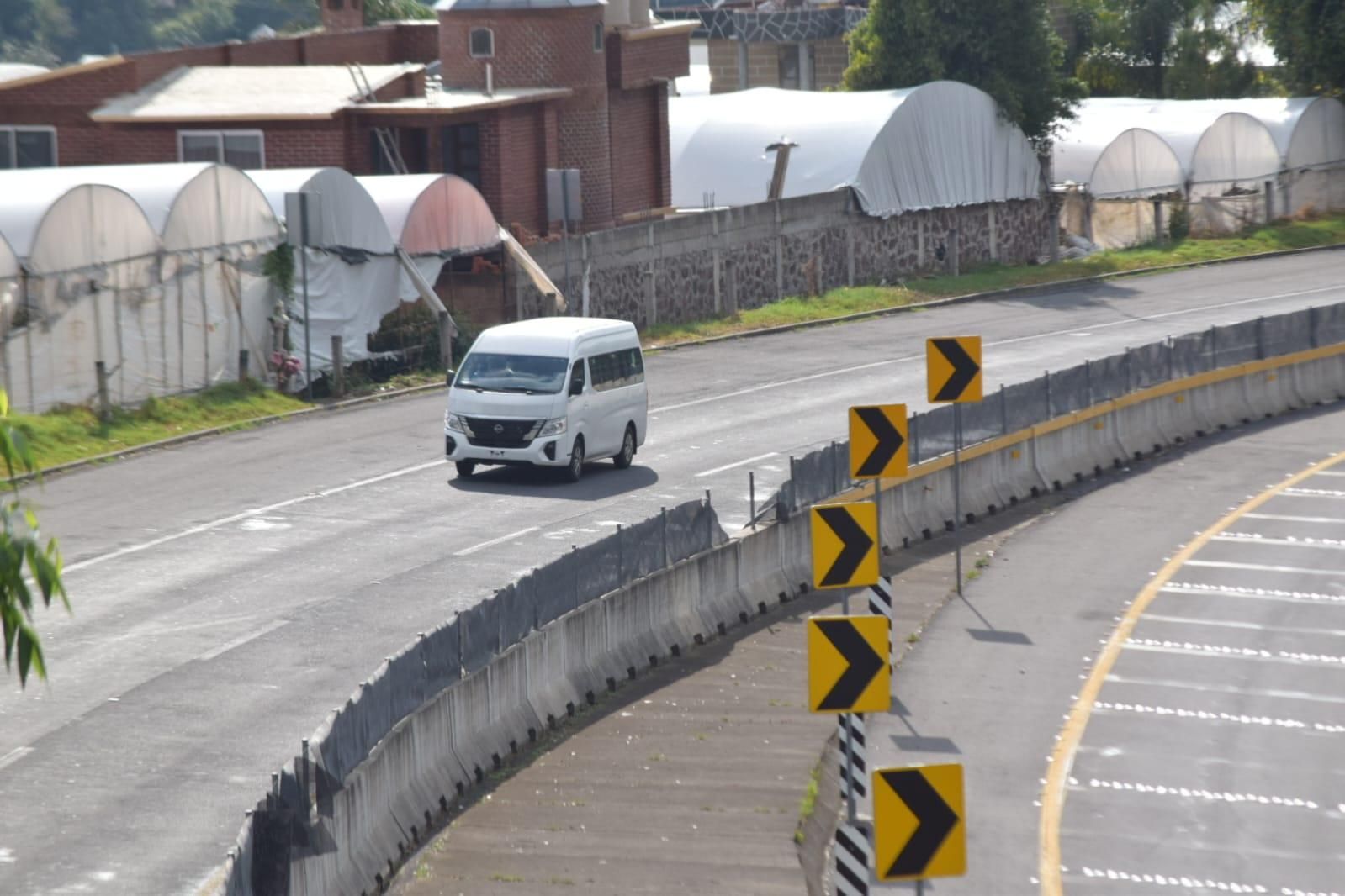 Curva de la autopista junto a invernaderos.