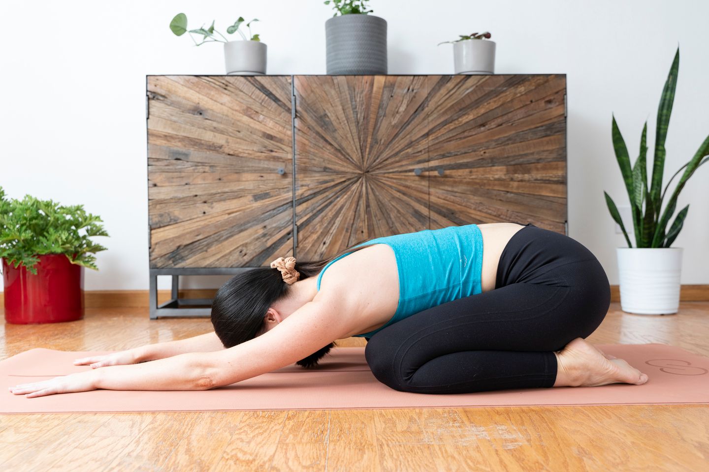 A woman who lives with MS rests in a supported yoga pose.