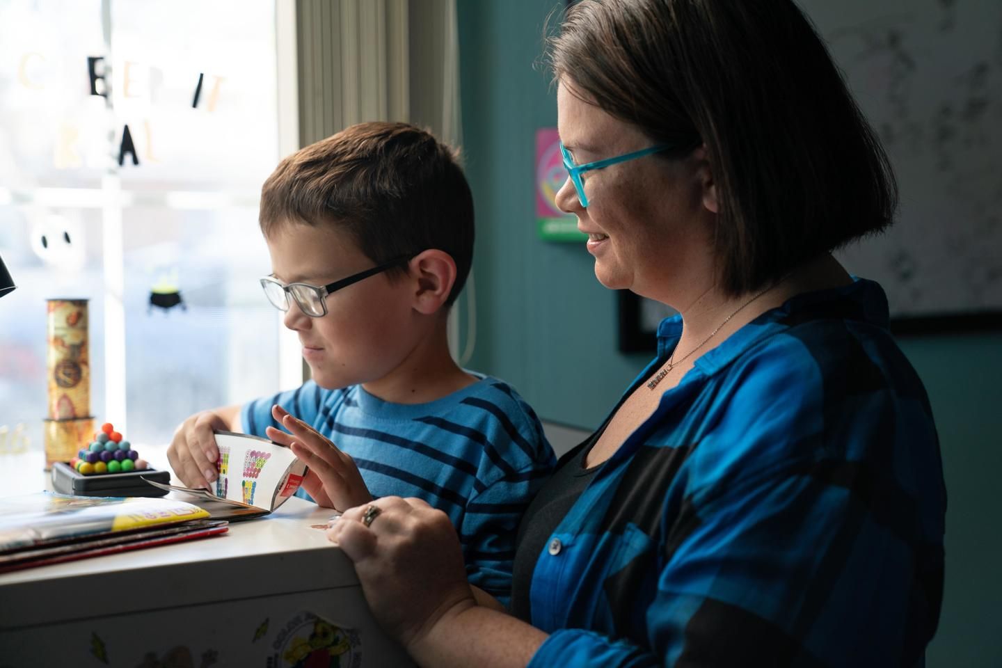 A woman who lives with MS looks at a book with her child.