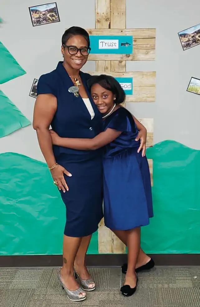 A black woman and her daughter hugging.