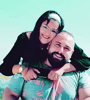 Marcel Steinbach holds his wife on his back as they both smile at the camera