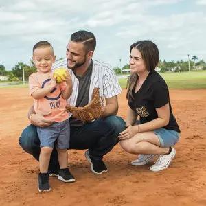 Man with wife and child on a softball field