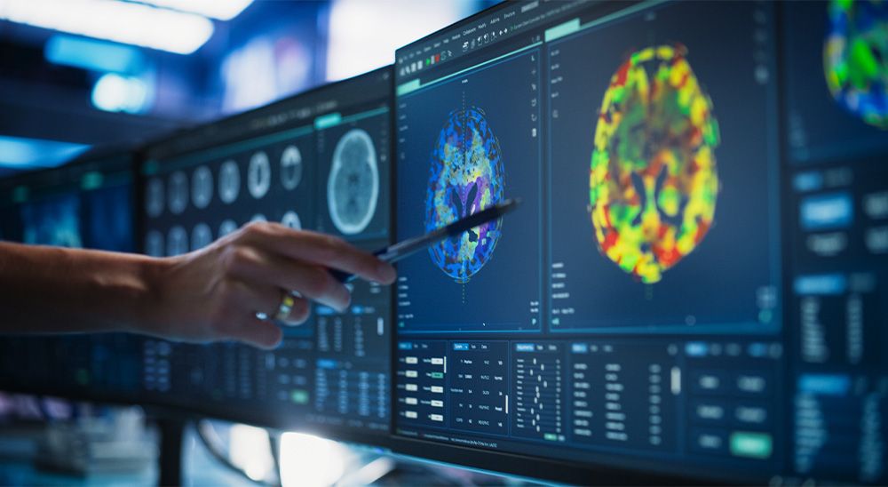 Hand of a female specialist pointing at desktop computer monitor with CT scan of spinal cord looking for tumors or damage.