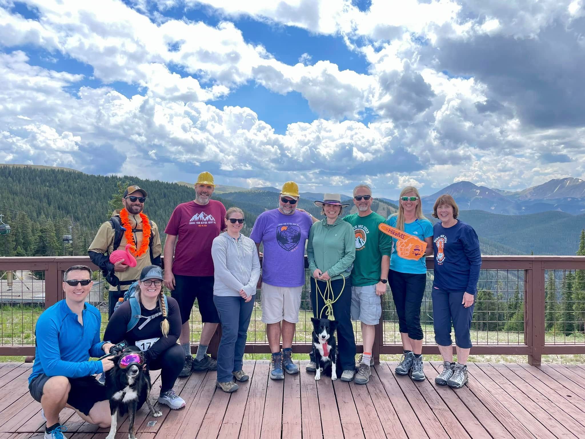 A group of people with mountains in the background pose for a picture.
