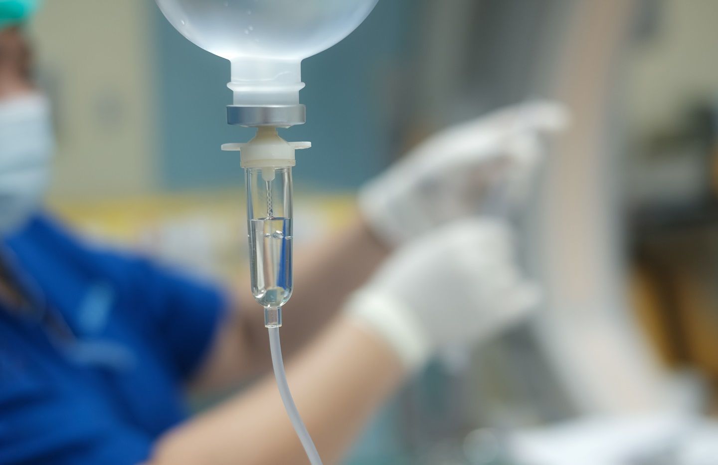 A medical professional prepares an infusion treatment