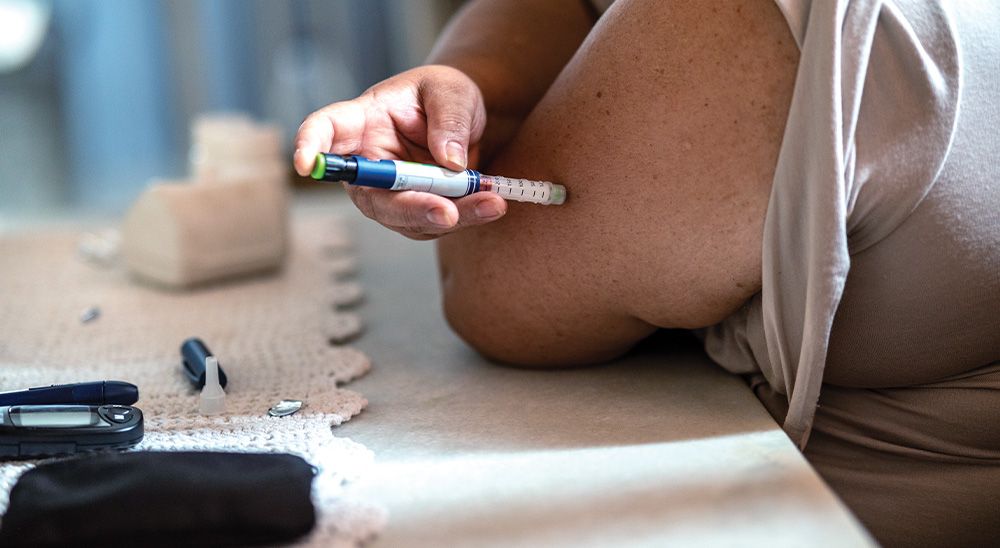 A person injects medication into their arm.