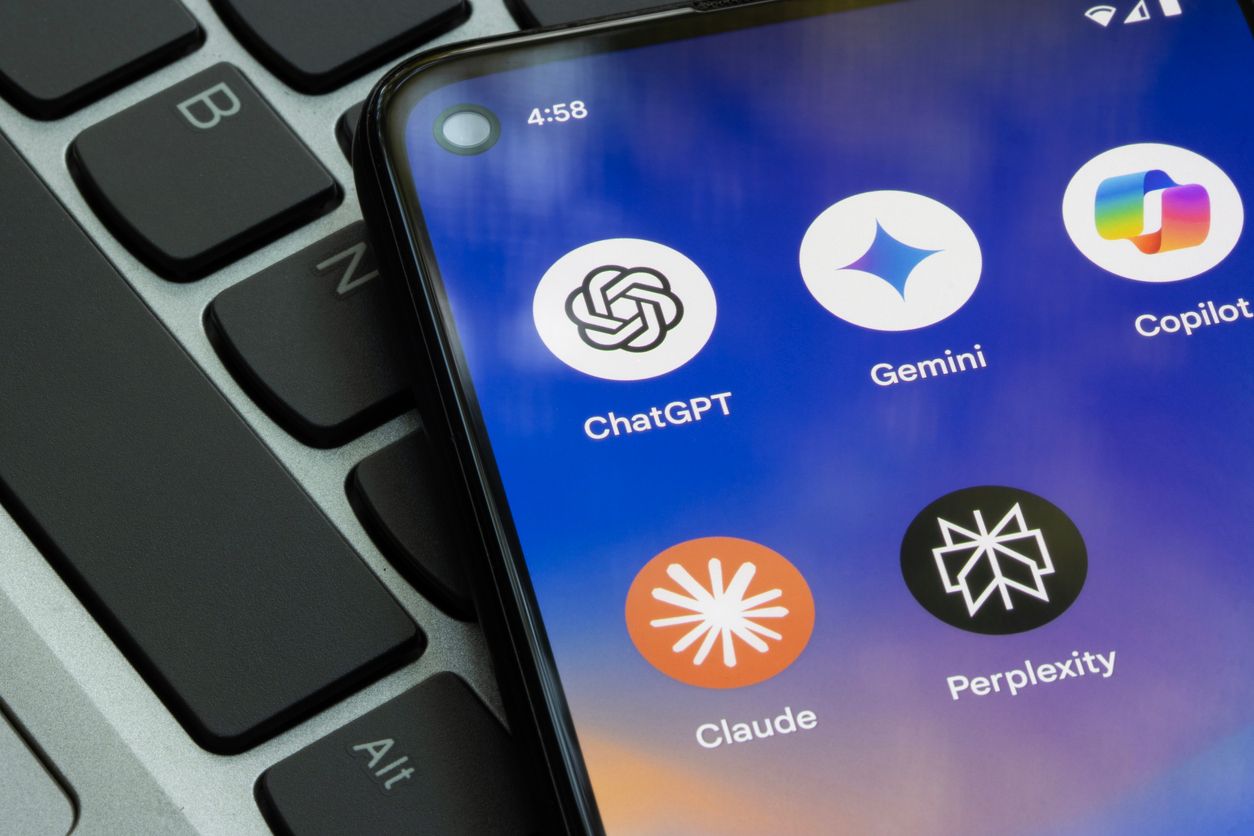 A cellphone sitting on computer shows the icon for the ChatGPT application.