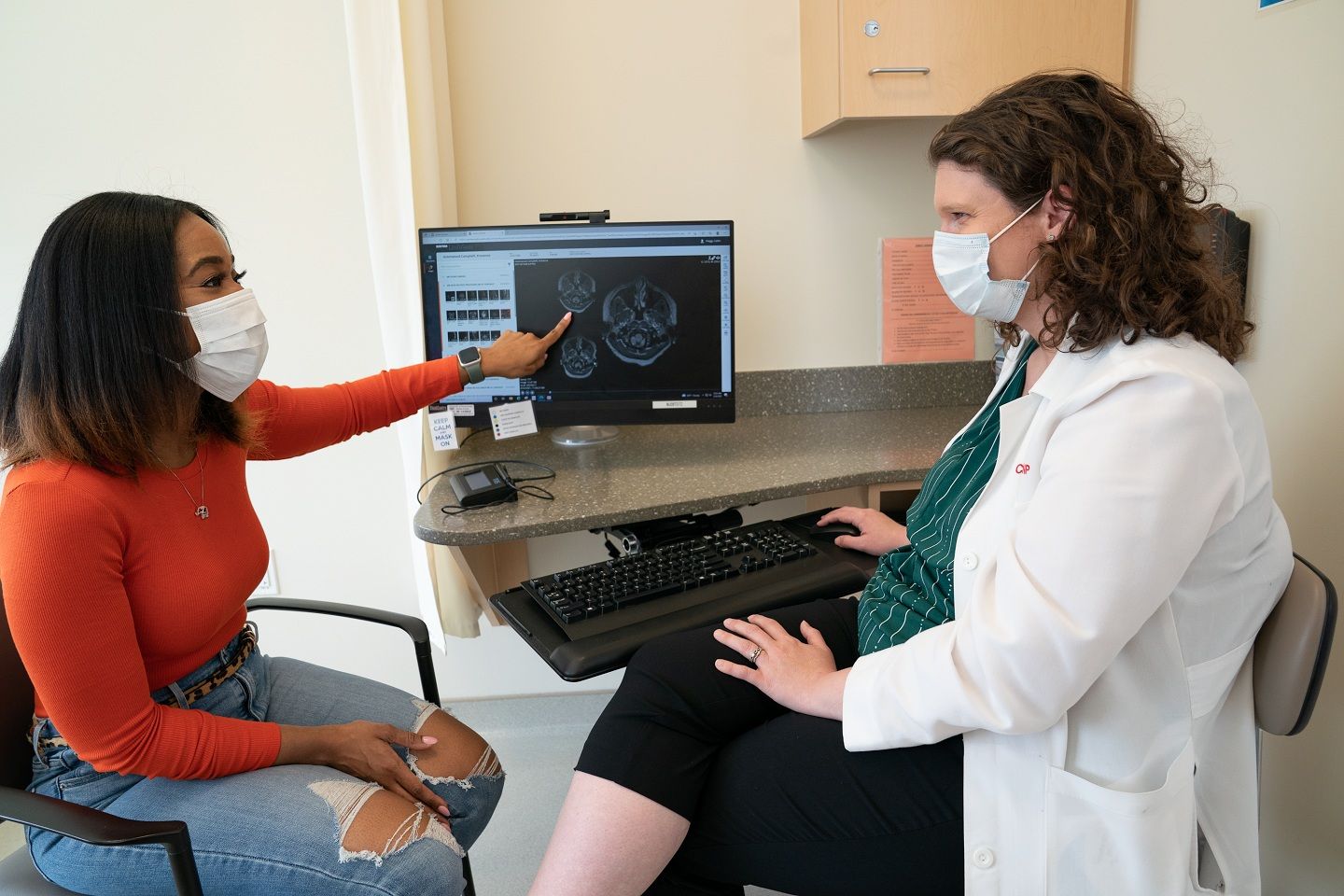 A woman who lives with MS points out something on her MRI to her MS doctor.