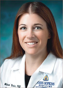 A young, white woman wearing a Johns Hopkins Medicine white coat.