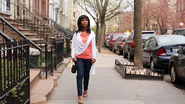 Anne Marie, diagnosed with MS, walking on the sidewalk along a busy residential street.