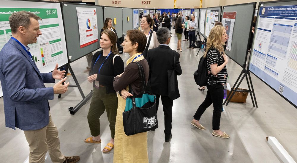 People explore research posters at a conference.