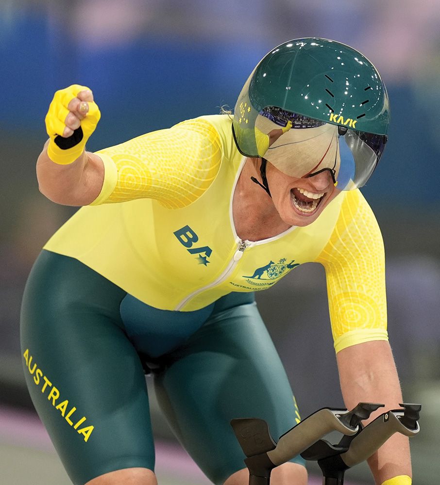 Emily Petricola rides her bike with a triumphant look on her face.