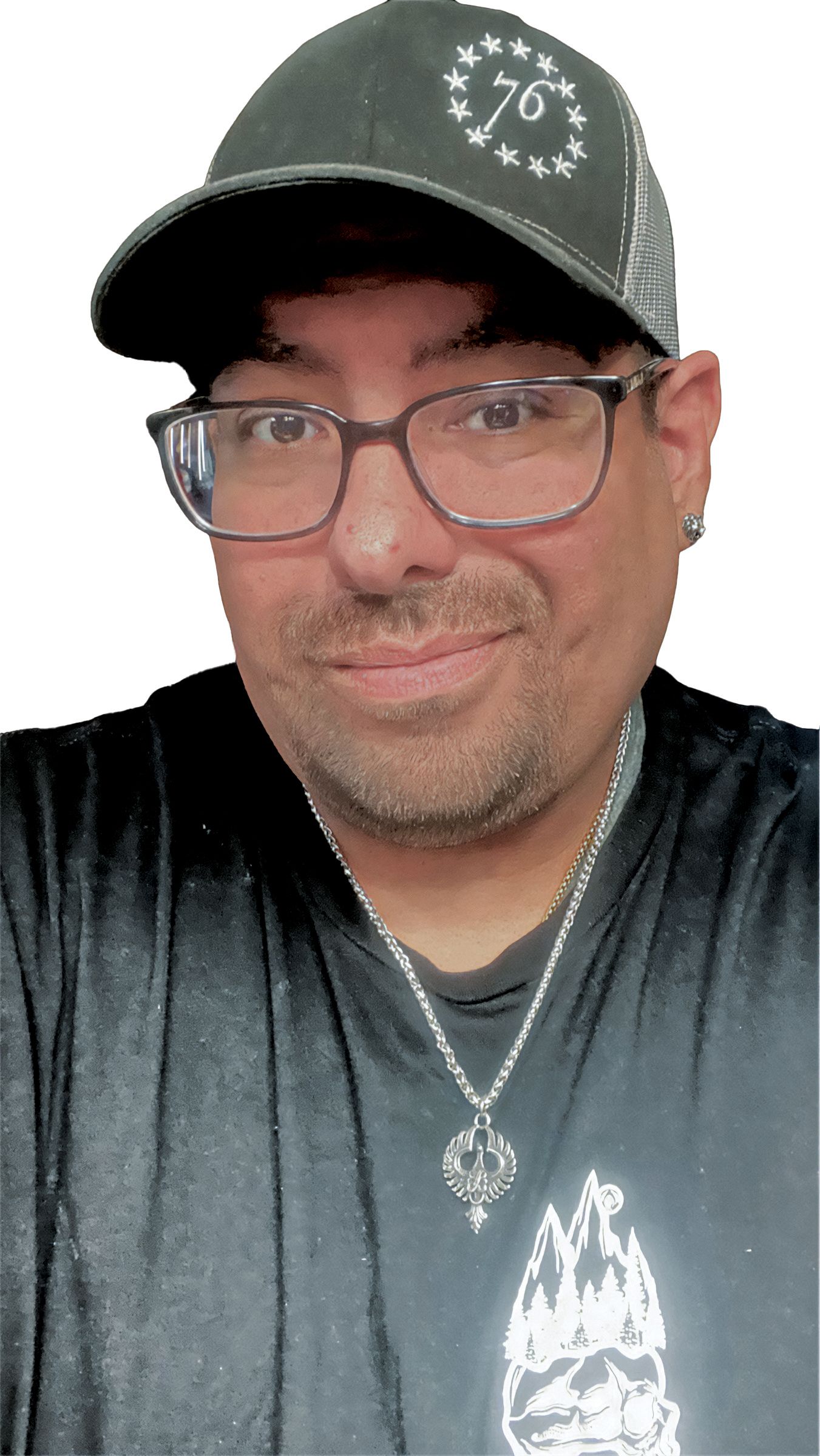 A man in glasses and a baseball hat, posing against a neutral background.