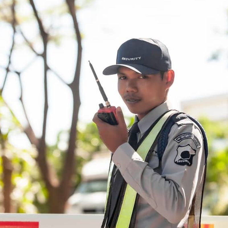 Whitehand security guard on duty with a radio at a gated premises in Bangalore, reliable security solutions