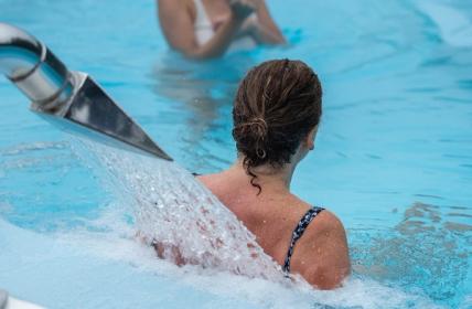 Women with water pouring on her back to relax in the AquaTherapy Pools at Hanmer Springs Thermal Pools & Spa.