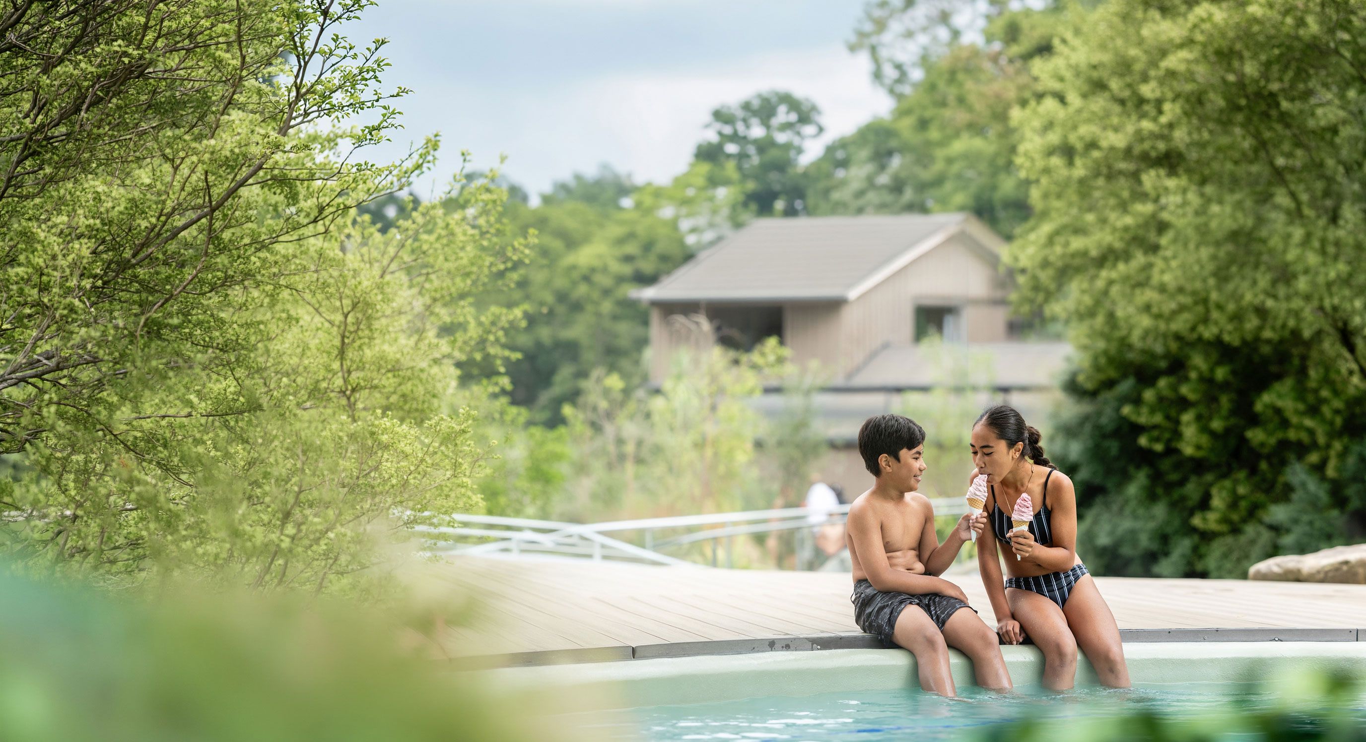Brother and sister enjoy ice cream together poolside in front of the Tea Kiosk cafe at the Hanmer Pools