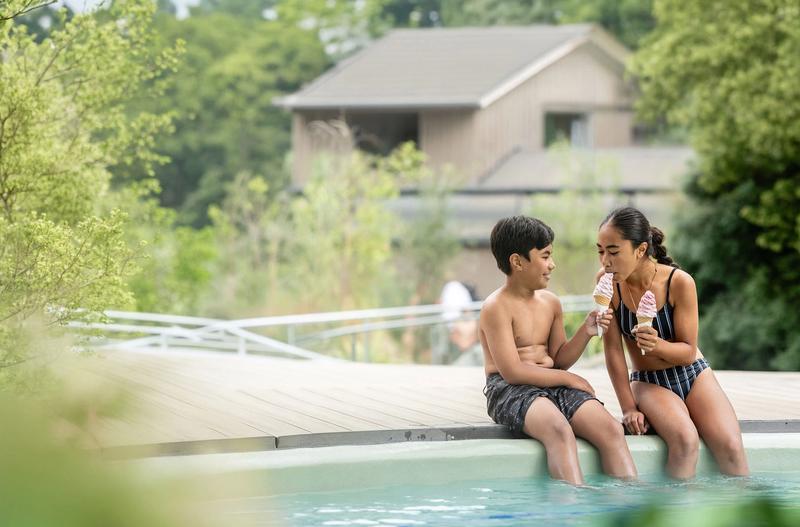 Brother and sister enjoy ice cream together poolside in front of the Tea Kiosk cafe at the Hanmer Pools