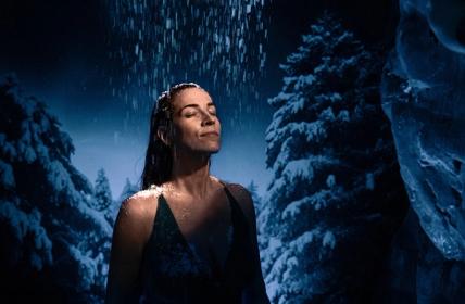 Young women with here head under the Snow shower in the snow room.