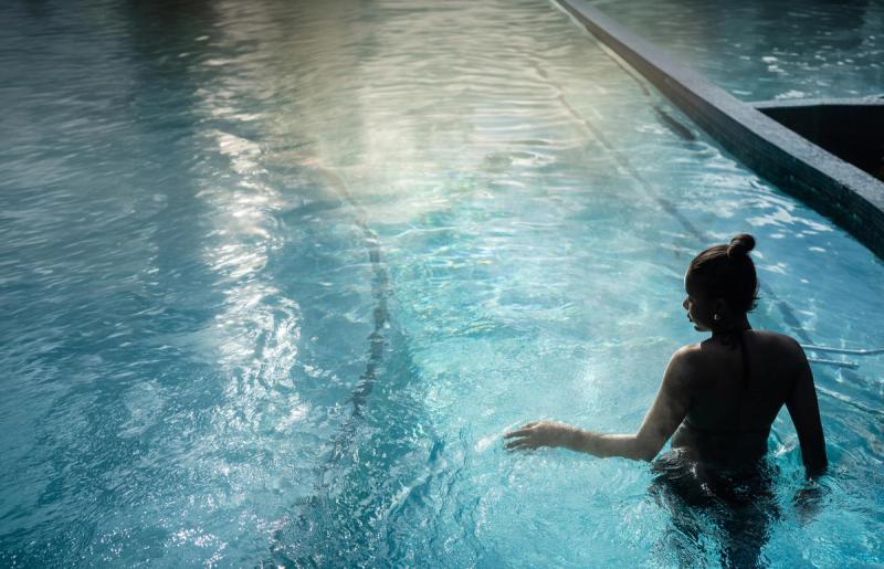 Woman with her hand to her side, brushing the water as she relaxes at night enjoying Hanmer Spring hot pools