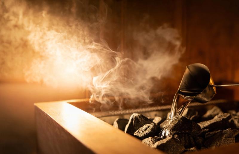 Water poured over hot sauna stones, steam rising