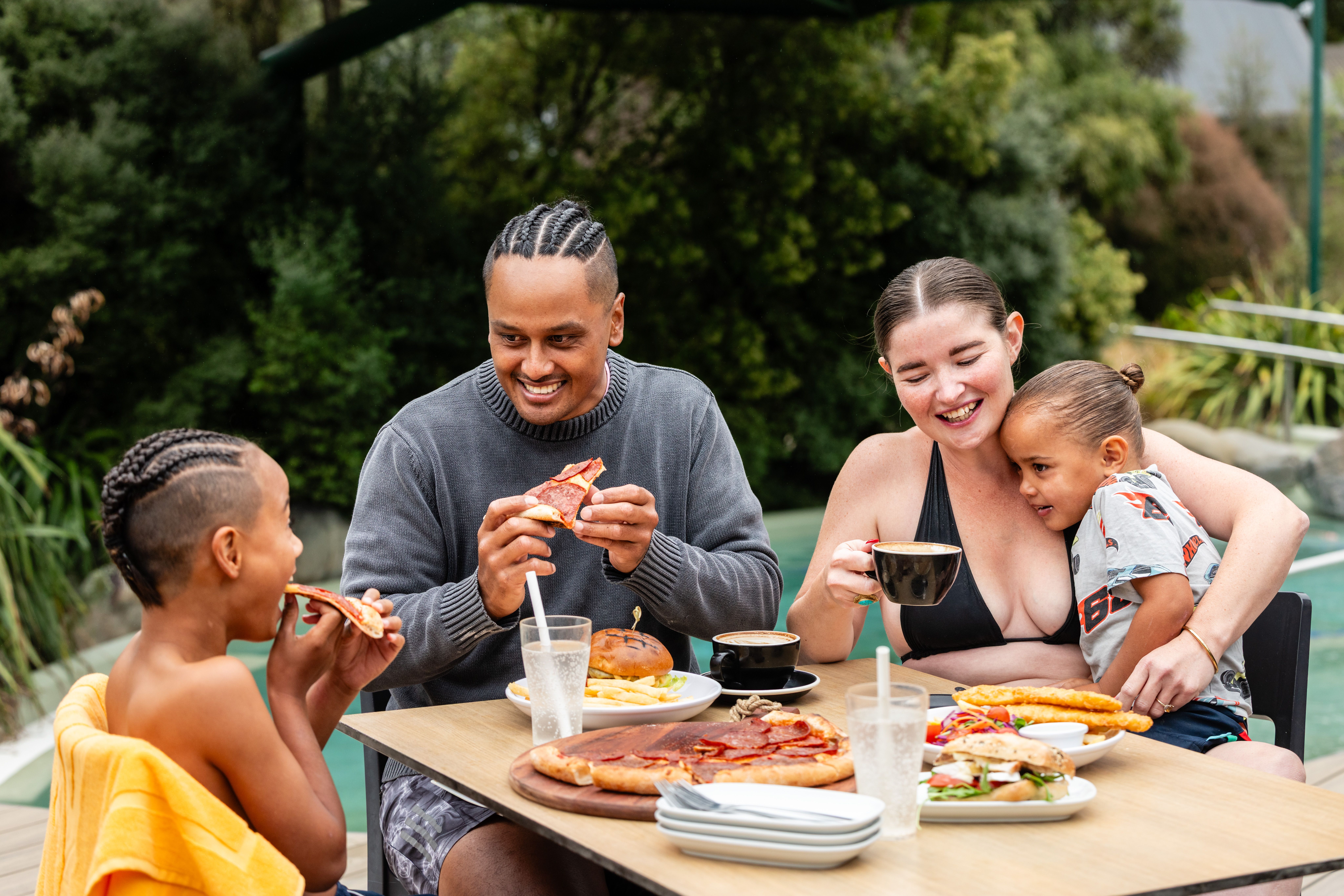 Family enjoying a pizza pool side celebrating Fathers Day