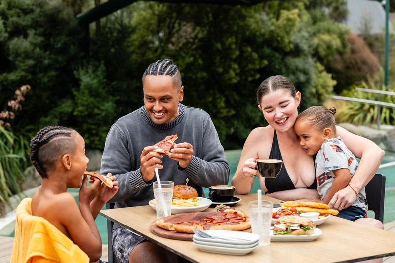 Family enjoying a pizza pool side celebrating Fathers Day