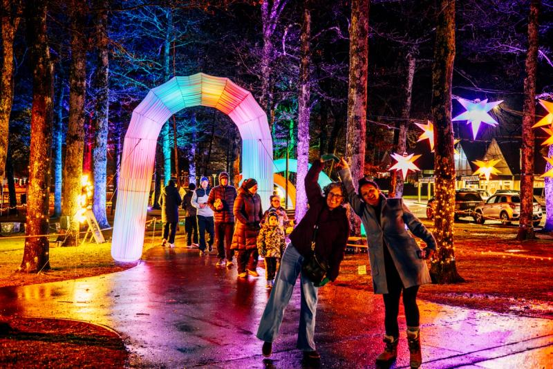 Families and friends walking through the colourful lights display on Amuri Ave 